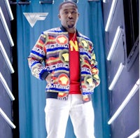 a man in a colorful jacket standing in a room