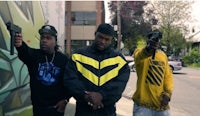 three men standing next to each other holding guns