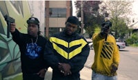 three men standing next to each other holding guns