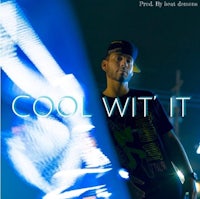 a man standing in front of a neon light with the words cool wit it