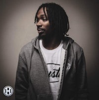 a man with dreadlocks in a gray hoodie
