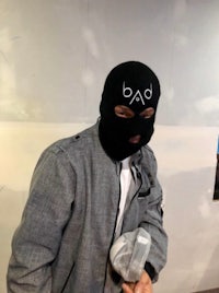 a man in a black mask holding a bag