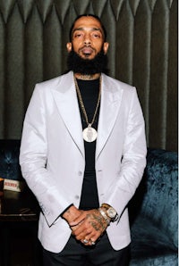 a man with a beard standing in front of a couch